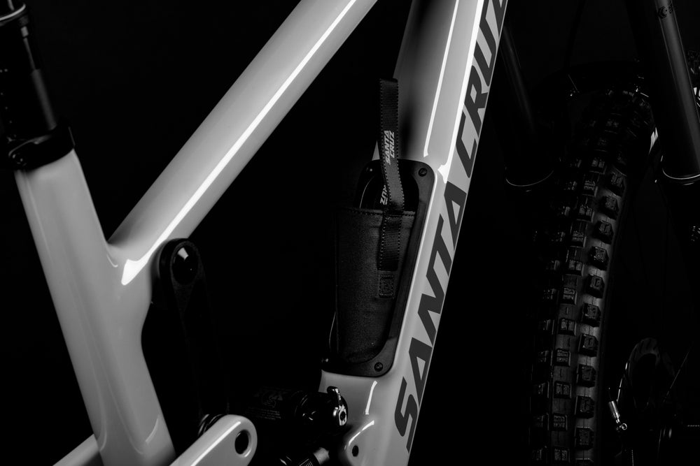 Close-up of a bicycle frame with 'Santa Cruz' branding on a black background