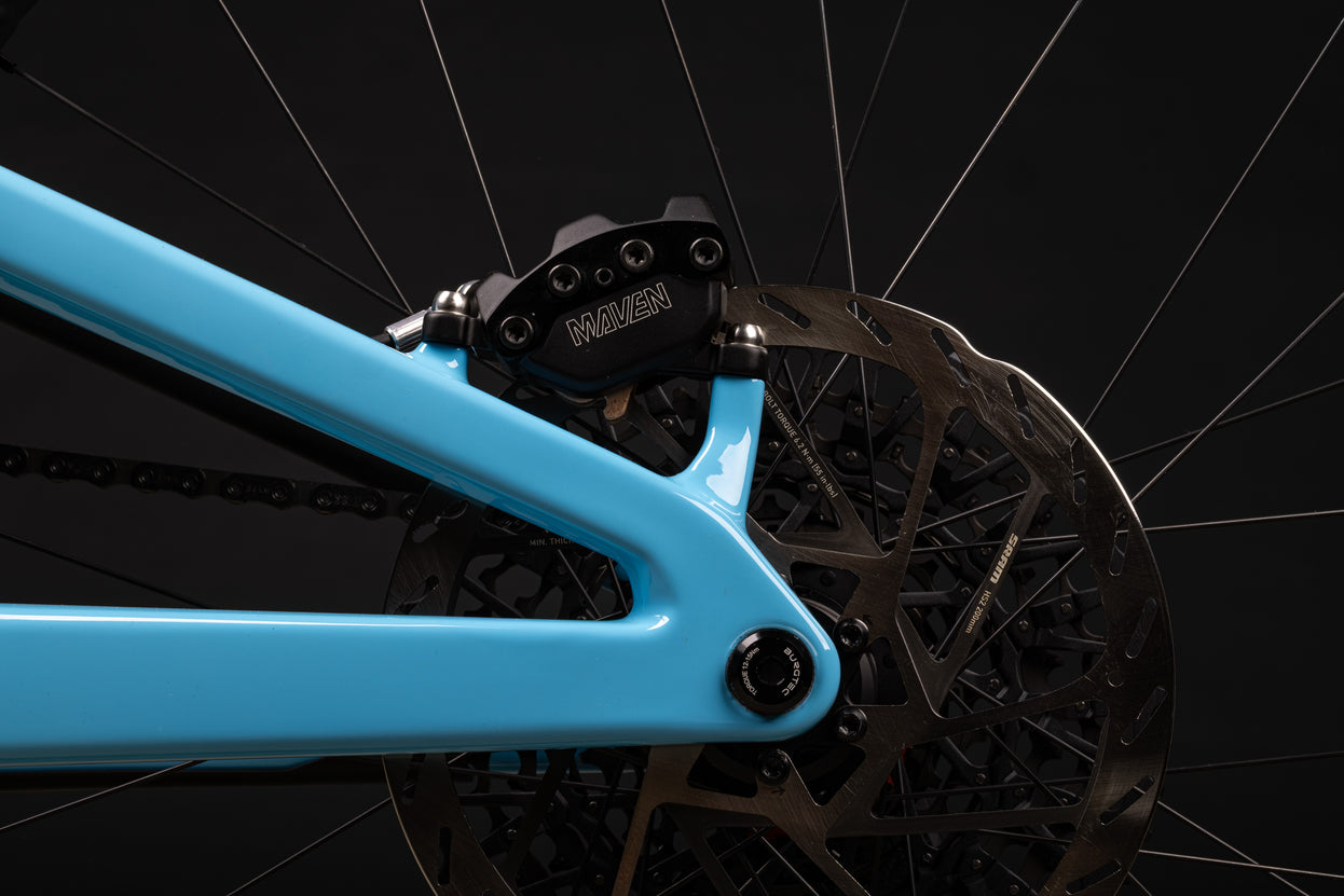 Close-up of a bicycle's chain mechanism with a blue frame against a black background
