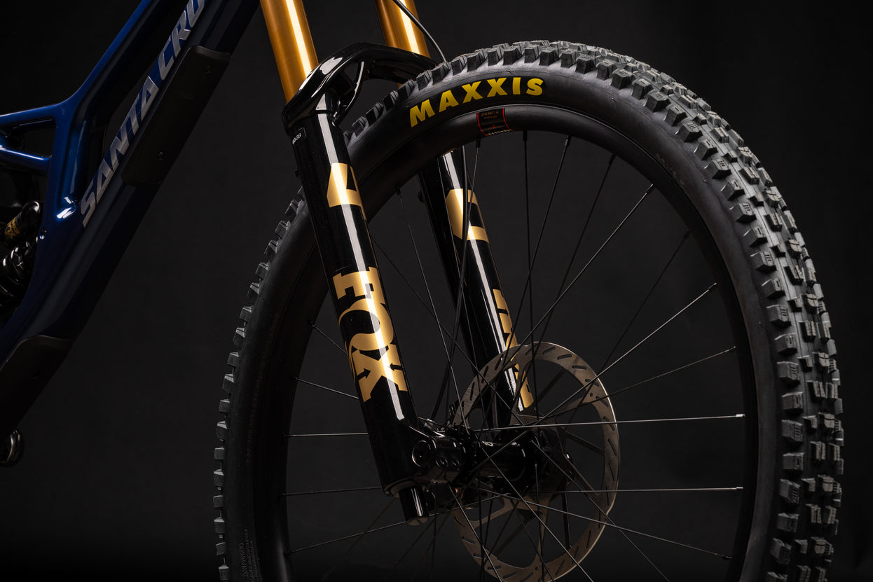 Close-up of a bicycle fork with Maxxis tire on a dark background
