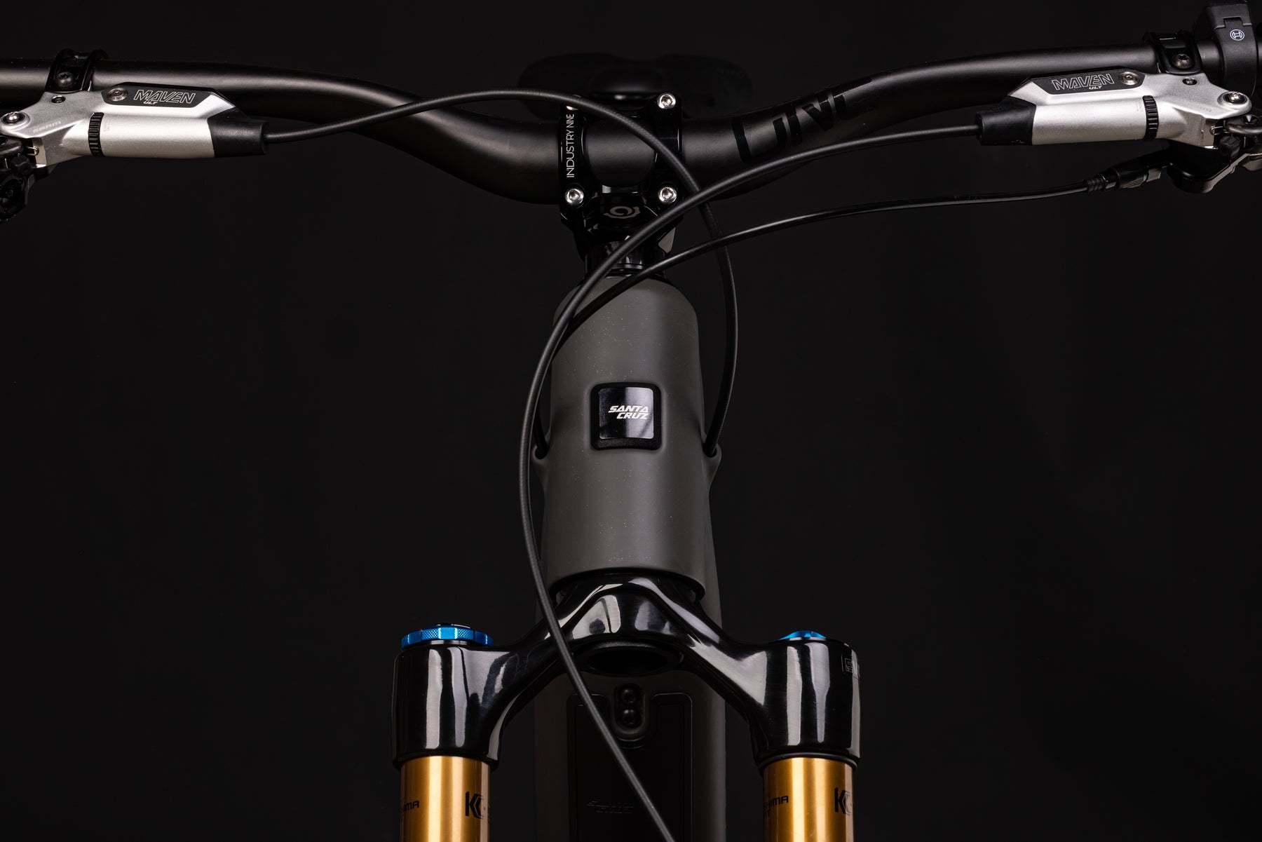 Close-up of a bicycle handlebar with electronic components on a black background
